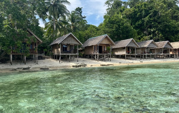 a beach with a hutch and a boat in the water