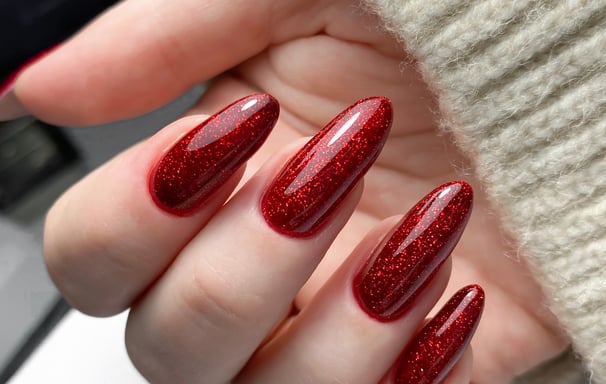 a person's hand holding a red manicured manicured manicure