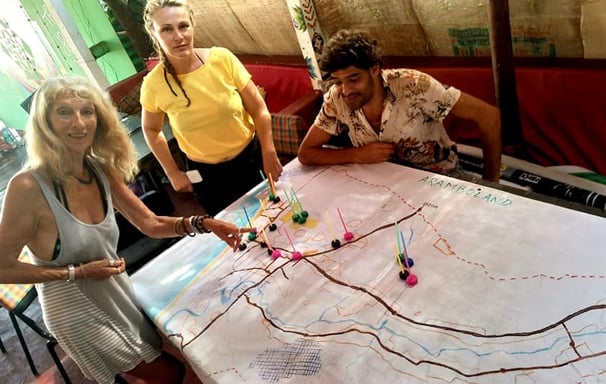 a group of people standing around a table with a map