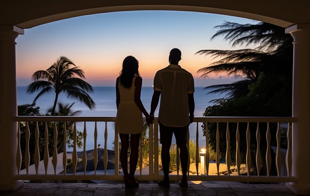 A couple enjoying the views of the Caribbean in their rented villa's balcony.