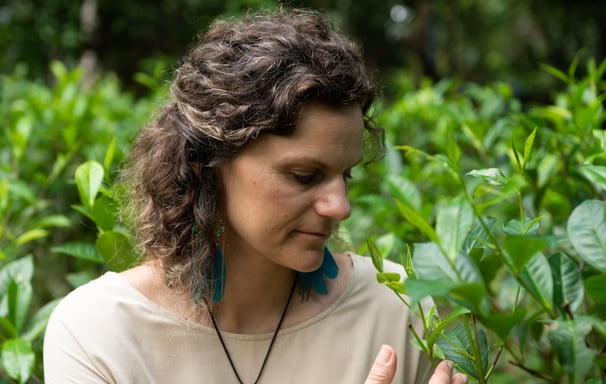 a woman in a white shirt and a necklace with a necklace