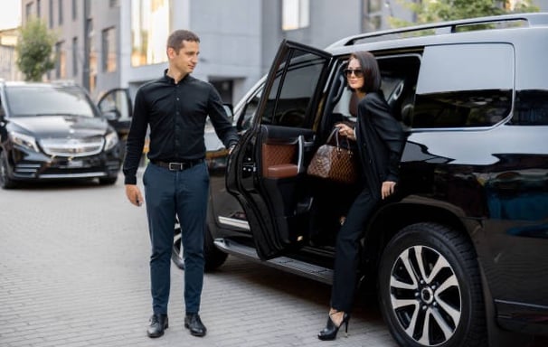 a man and woman walking away from a car