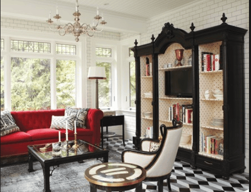 a living room with a red couch and a black and white checkered rug