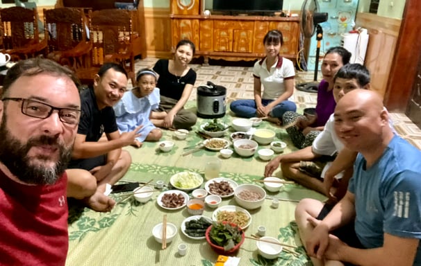 a group of people sitting around a table with food