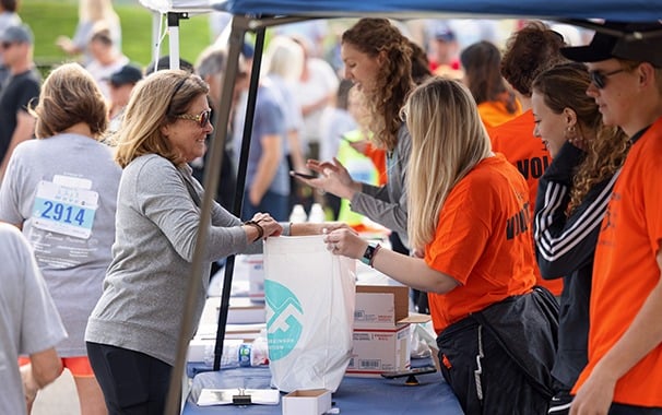 a photo of a runner completing their packet pickup before a race