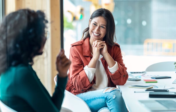 Two women having a positive and engaging conversation in a modern office.