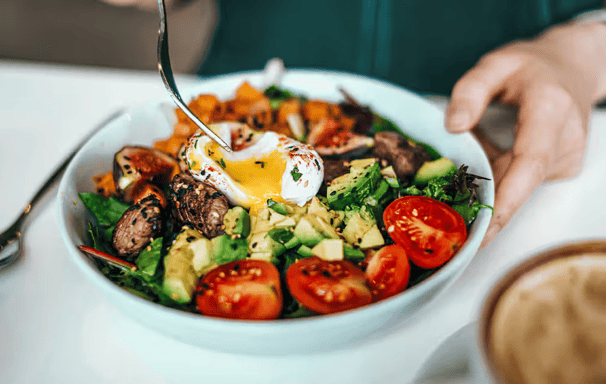 a person is eating a salad with eggs and eggs