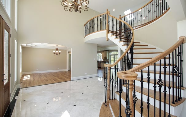 This elegant staircase features rich hardwood treads and handrails with ornate black balusters.