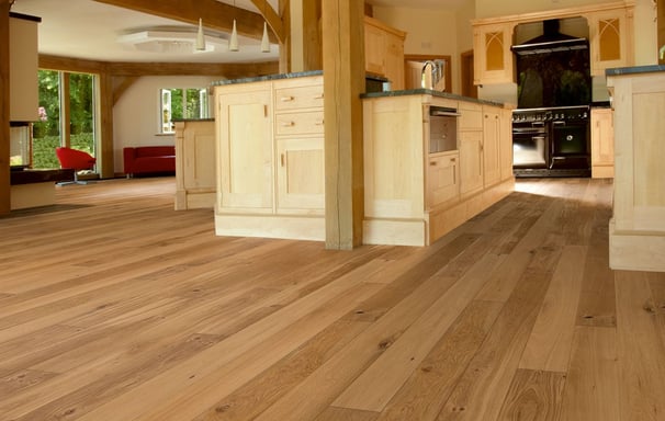 Wide plank hardwood floors in kitchen and living area, natural wood tones with functional elegance.