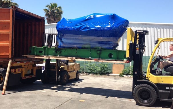 a large product with blue covered being loaded into a truck