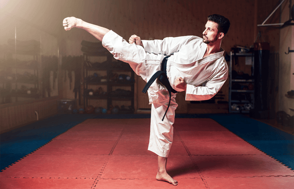 a man in a karate outfit is doing a kick kick - kick
