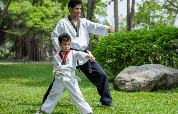 a man and a boy are practicing karate moves