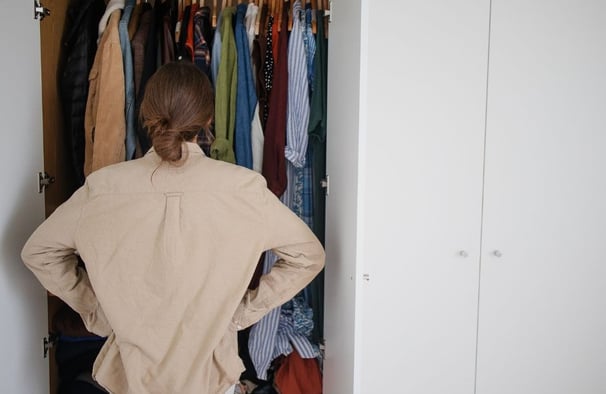 a woman standing in a closet with a closet full of clothes