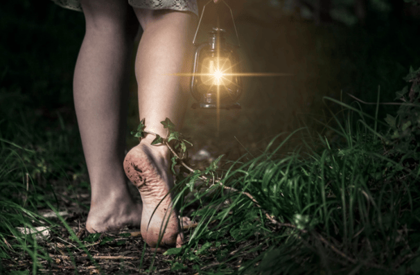 personne marchant pieds nus avec une lanterne a la main symbolisant mon parcours ma mission