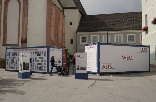 Besucher erkunden die Außenanlage der mobilen Ausstellung "Aus weg los!".