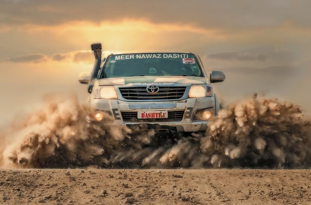 a truck driving through a dirt road