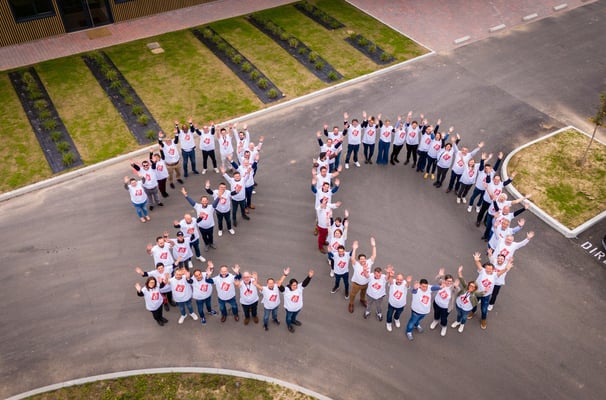 a group of people standing in a circle with a large heart shaped sign