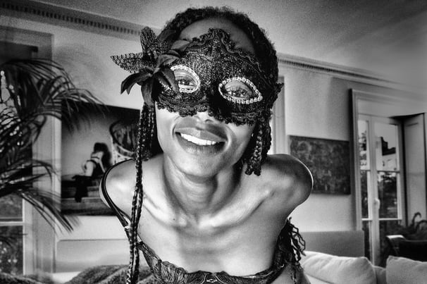 Belle jeune femme noire avec un magnifique sourire et un masque qui porte des bas 
