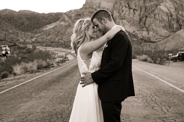 a bride and groom kissing on the road