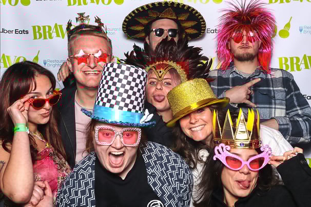 Group of young people posing for Get The Picture vintage photo booth in fun props