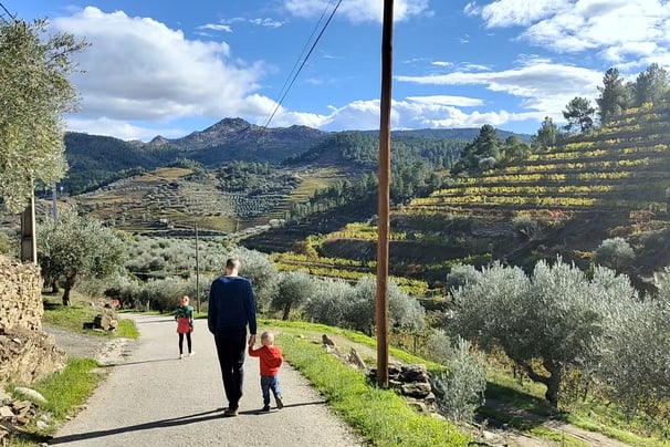a man and two children walking down a path