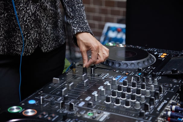 Ein weiblicher DJ nimmt Einstellungen vor.