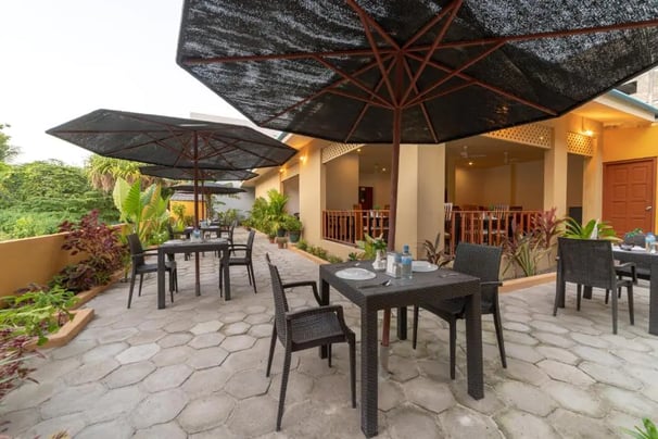 a patio with a table and chairs and umbrellas