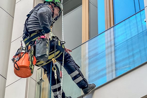 a man in a helmet is climbing up a building