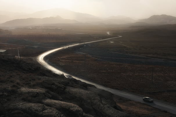 a car driving down a winding road in the mountains