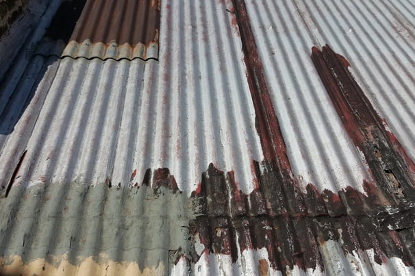 Advanced corrosion and material failure on metal roofing, example of roof beyond repair stage