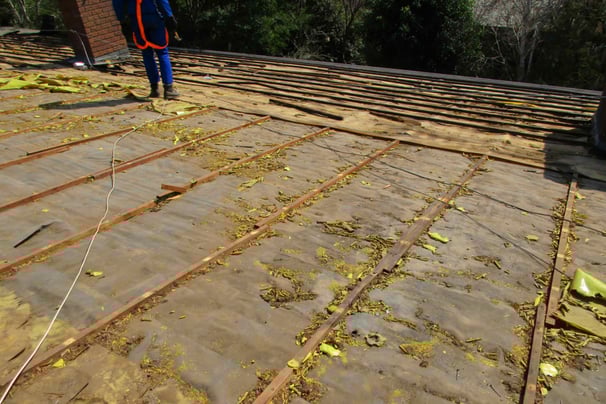 Old tile roof stripped down, showing deteriorated battens and perished underlay on a West Rand roof