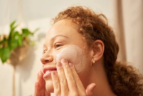 women washing her face using a gentle cleanser