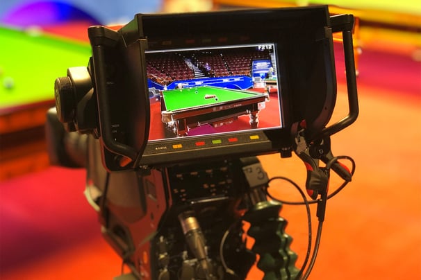 A close-up of a television camera monitor displaying a live feed of a snooker table at the World Snooker Championship..