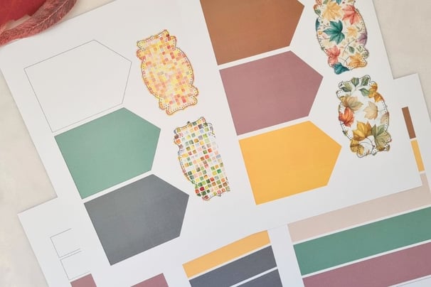 Colorful craft paper sheets featuring hexagonal shapes in muted tones and cutouts for card making