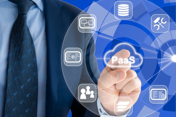 Businessman pressing PaaS icon on virtual screen with cloud service and architecture symbols