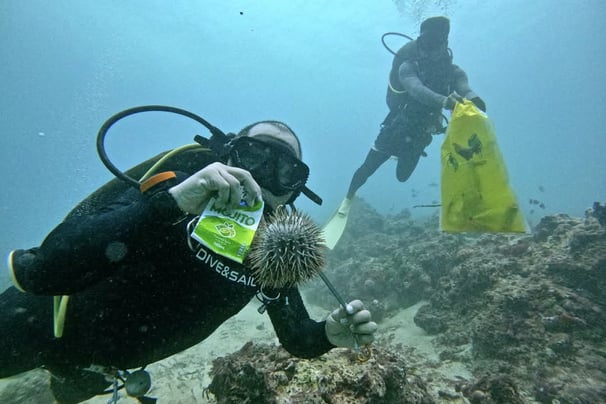 Scuba Diver Regie picking up trash and collecting crown of thorns out of the waters of Shangrila