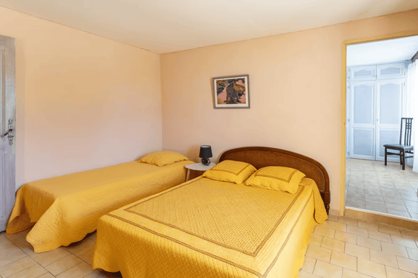 a bedroom with two beds and a door way to the bathroom