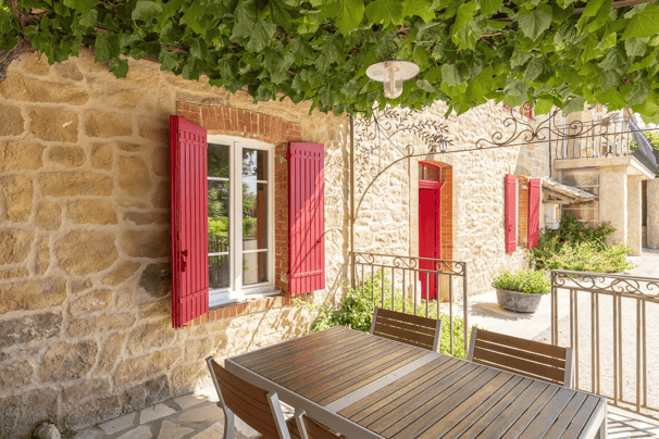 a table with a table and chairs in front of a stone building