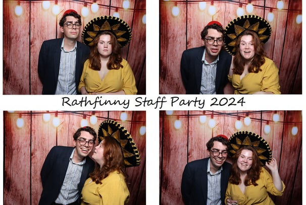 A couple posing for the get the picture vintage photo booth Brighton at a corporate party with a Mexican hat