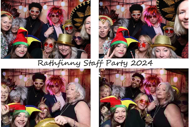 Guests at a staff party posing for the get the picture photo booth wearing silly fun wigs hats and glasses having lots of fun