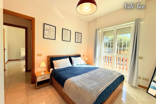 a bedroom with a bed and a balcony air conditioner
