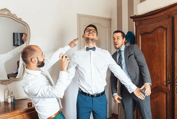 Préparatifs du marié avec ses témoins dans une ambiance joyeuse.