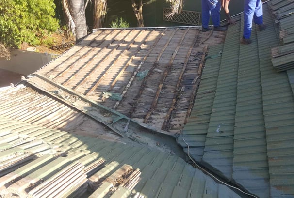 Non-compliant roof showing exposed battens and deteriorated waterproofing.