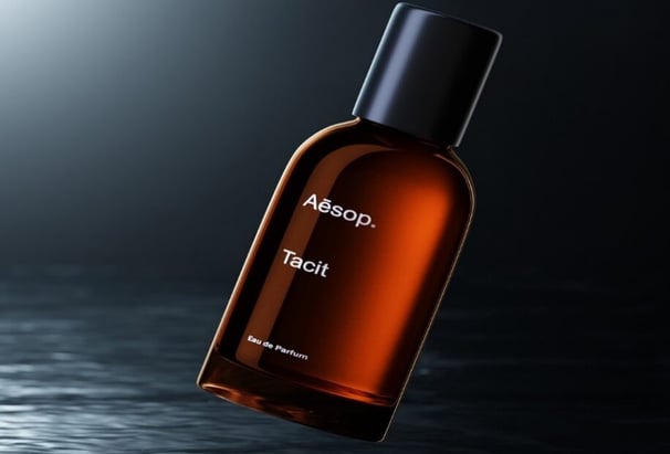 a bottle of cologne on a table with a black background