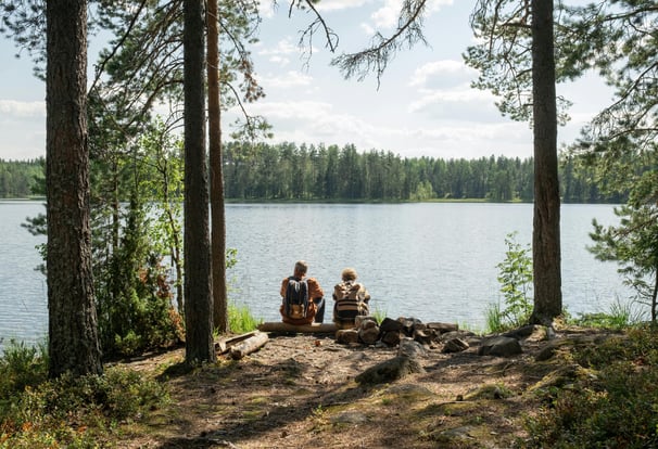 a couple sitting on a bench in the woods