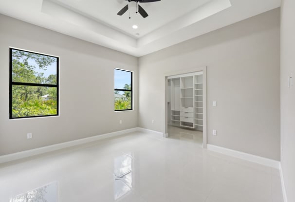 Master bedroom with porcelain tile, two windows and entrace to the walking in closet
