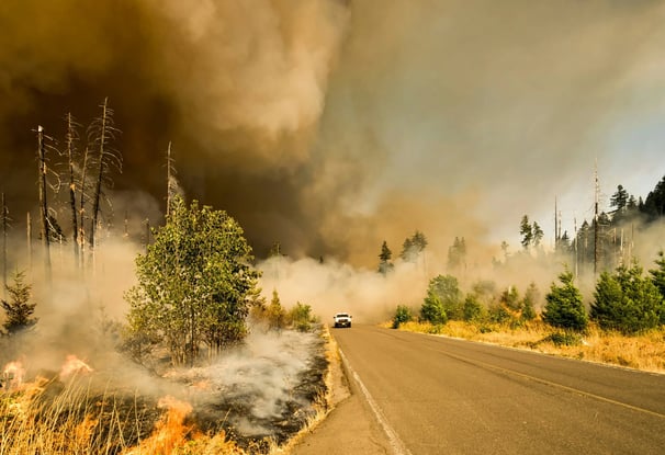 a car driving down a road with a lot of smoke