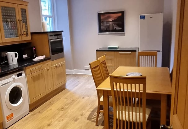 a kitchen at The kitchen at Gourock Seaview Holiday Let with a washing machine and dinner table