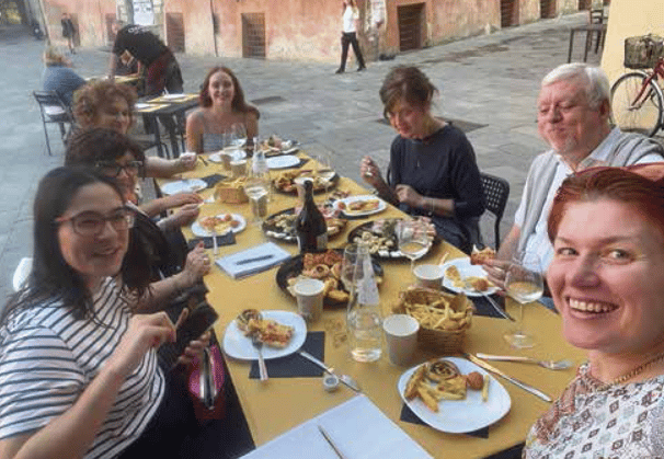 a group of people sitting at a table with food