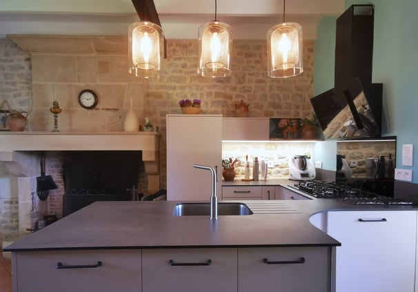 cuisine beige fermée avec îlot central. Portes anti traces de doigts. poignées tradition.